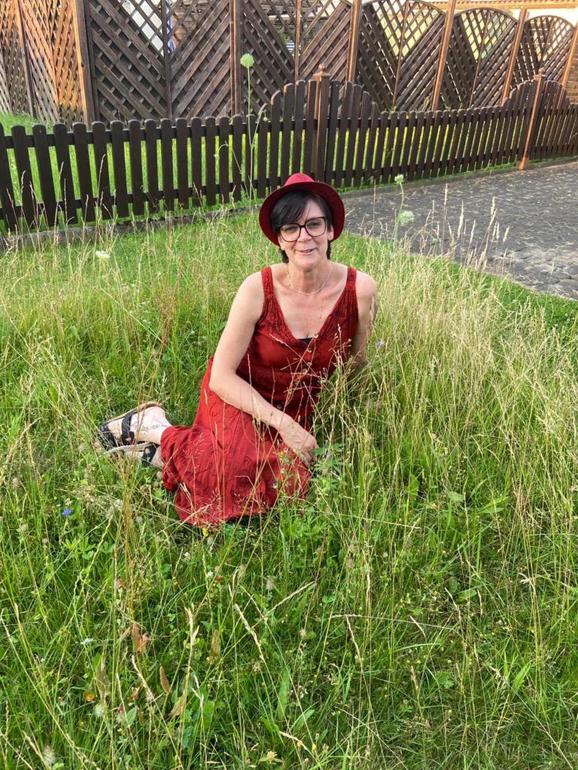 Manuela Möller sitzt auf Gras im Garten