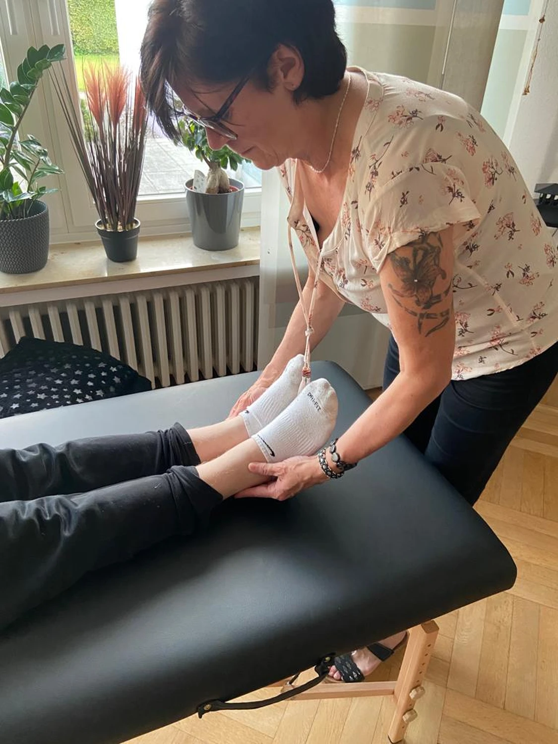 Manuela Möller drückt auf die Druckpunkte der Füße einer Frau