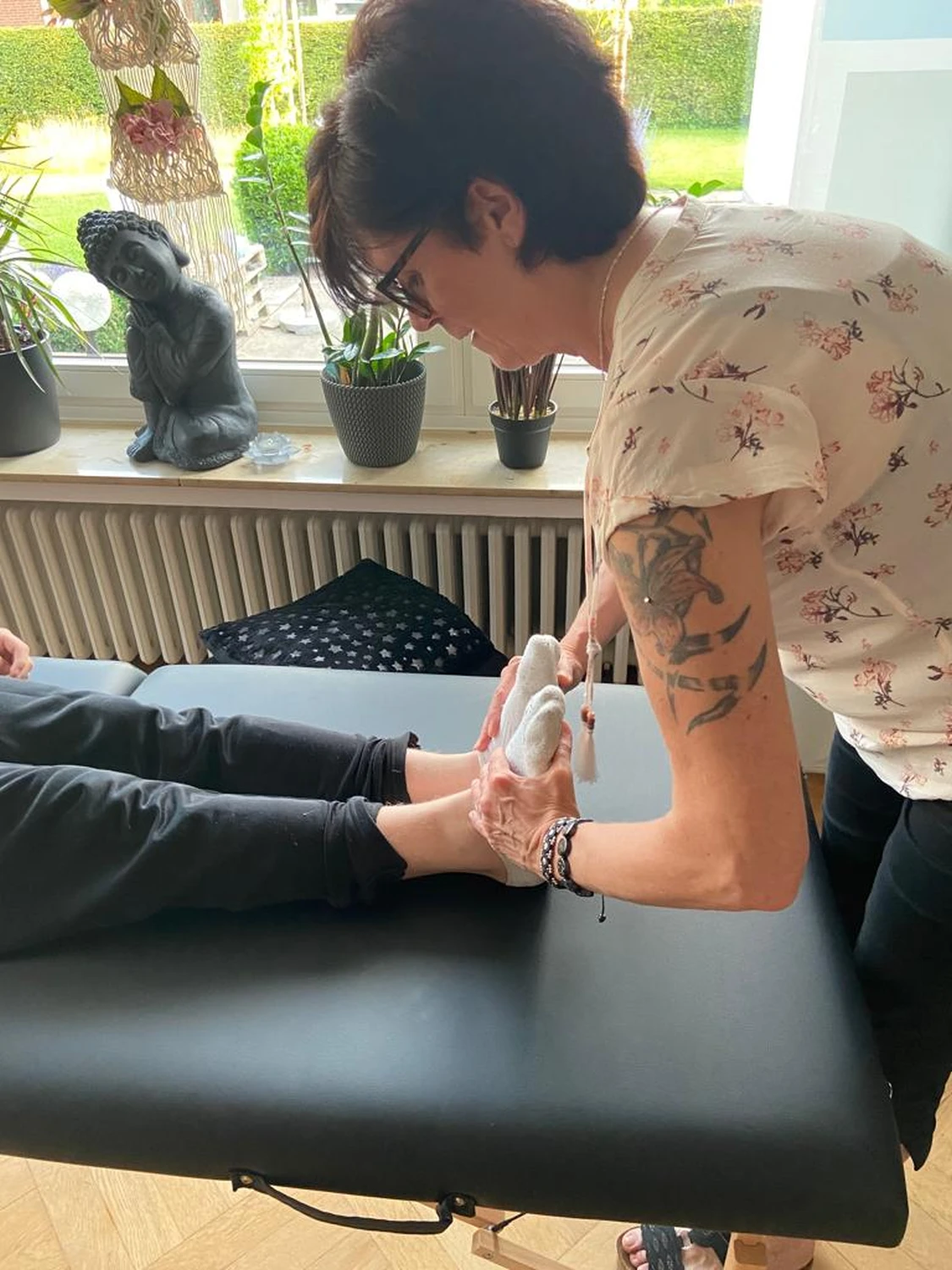 Manuela Möller drückt auf die Druckpunkte der Füße einer Frau